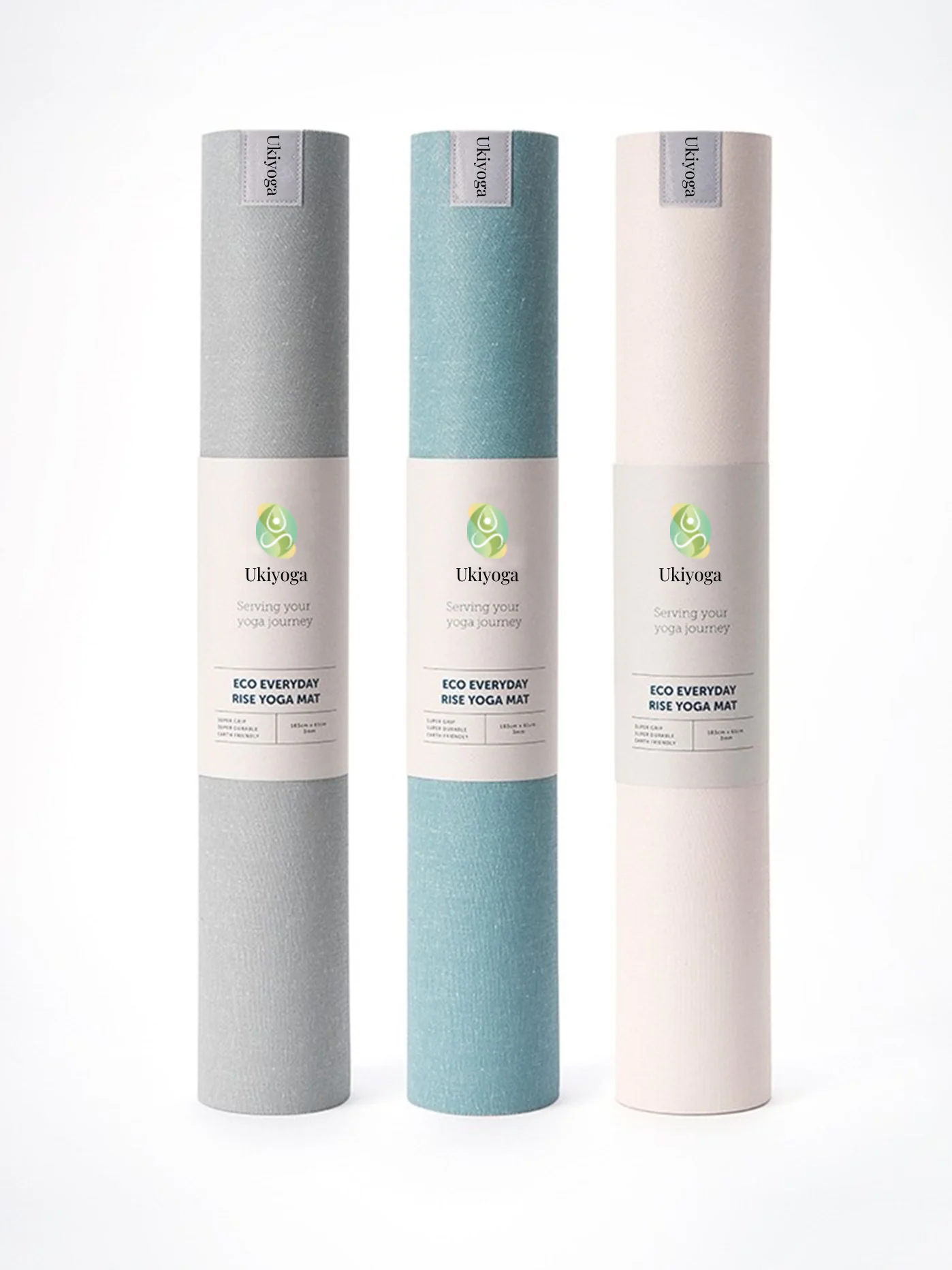 Tre tappetini da yoga arrotolati, grigio, azzurro e rosa, con la fascetta Ukiyoga